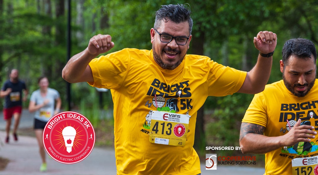 Man raising hands in victory crossing race finish line