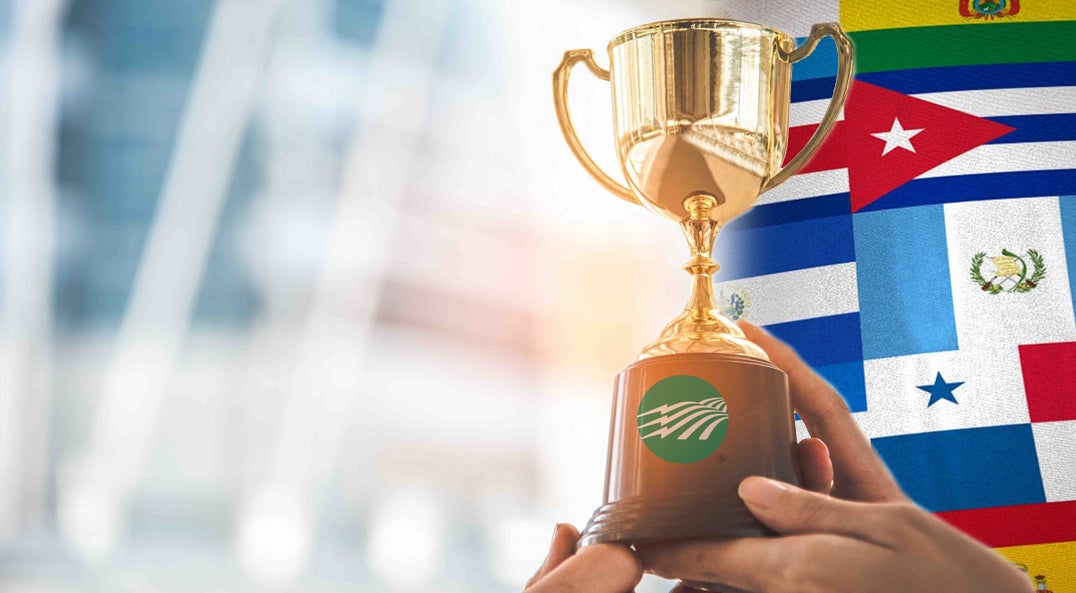 hands holding trophy in front of the flags of various Latin countries