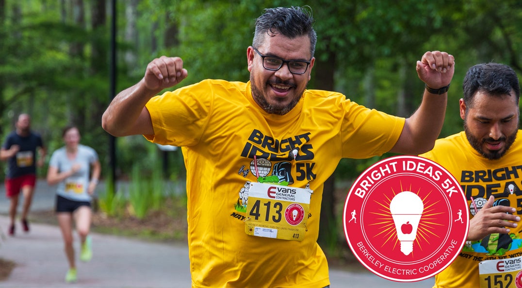 man raising his arms in victory crossing race finish line